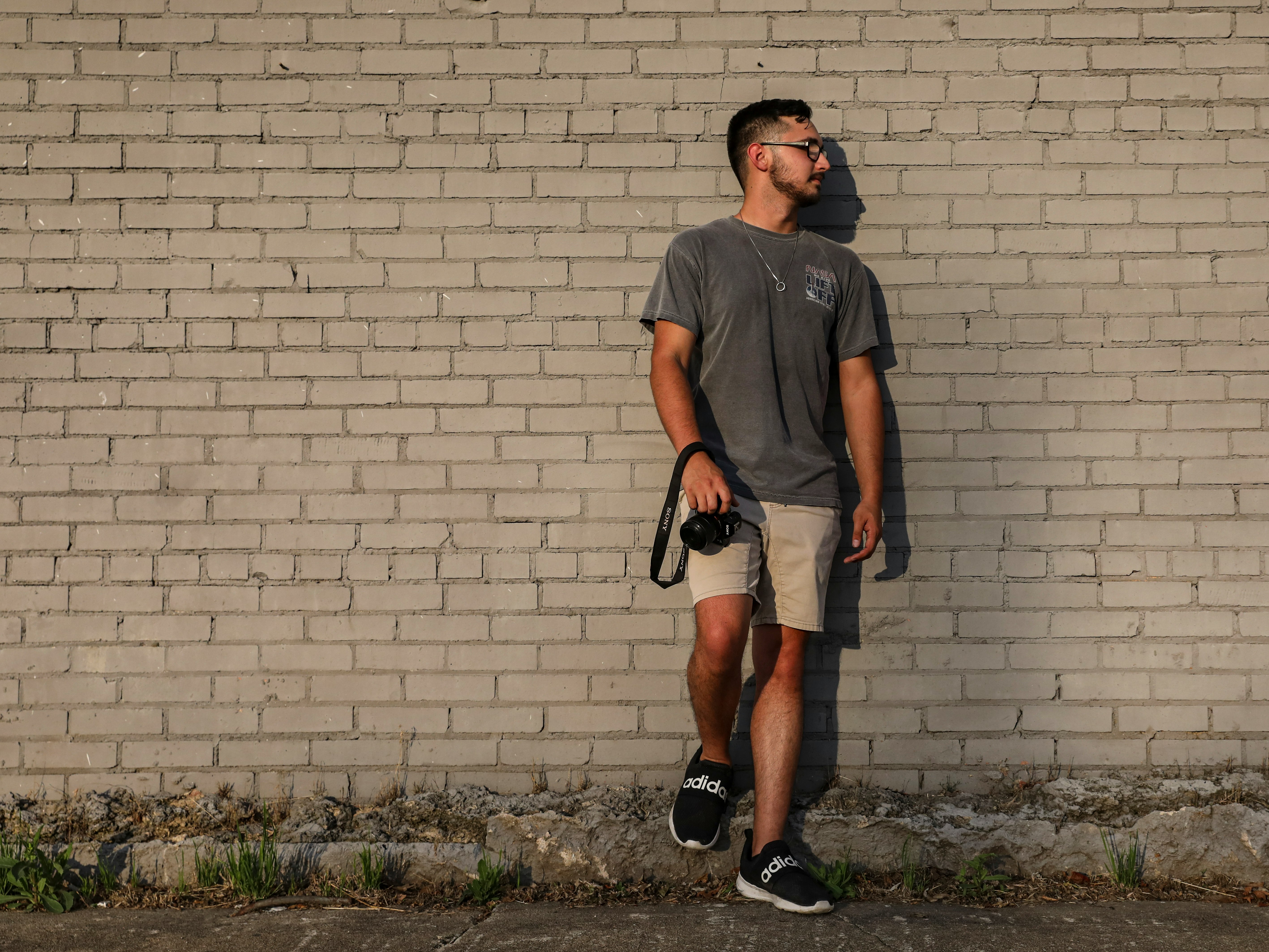 man in black crew neck t-shirt and black shorts standing on green grass field